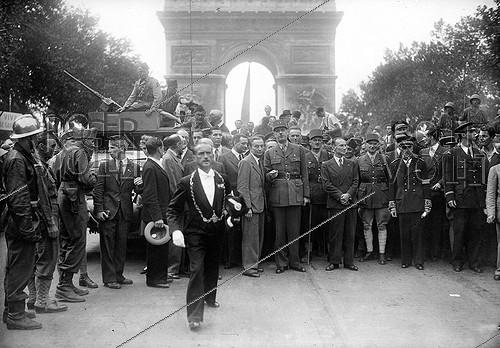 World War II. General Charles de Gaulle, at the Arc de Triomphe, with Joseph Laniel, Georges Bidault, General Leclerc, Alexandre Parodi, General Juin, Marcel Flouret, prefect of the Seine and Geoffroy de Courcel (second row, second from the left, profile). On the left : Pierre Dessance (St Cyr forage cap) in the police contingent of the parade. Paris, on August 26, 1944.
