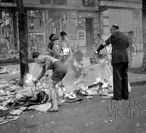 World War II. Liberation of Paris. Children tearing off and burning posters of the Occupation. Paris, August 1944.